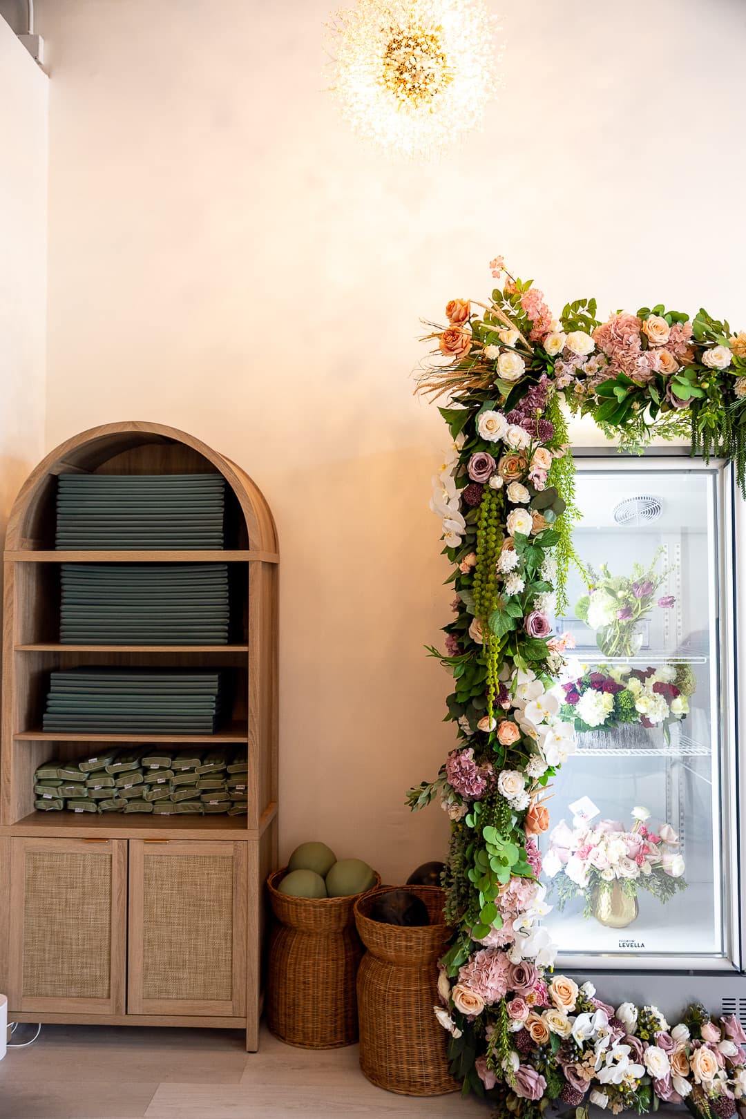 Stacked mats on the arched shelf beside the flower fridge